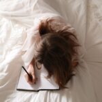 Woman writing in a bed